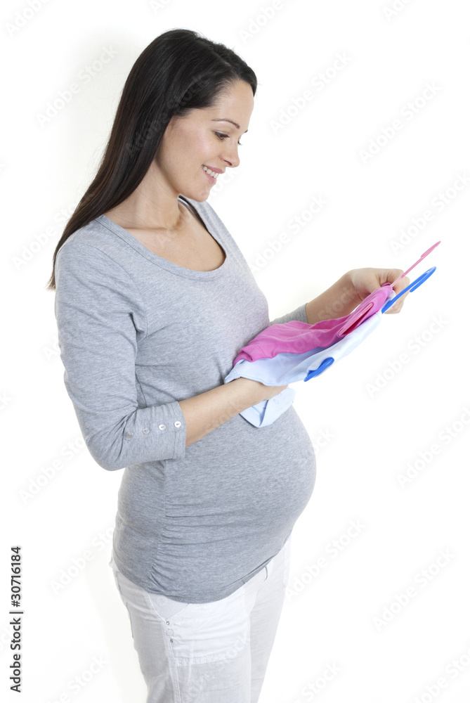 Pregnant woman looking at boy/girl baby clothes