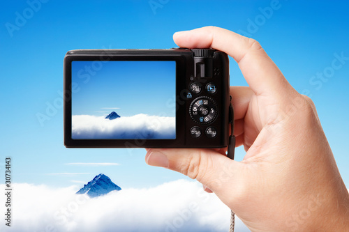 Tourist's hand holding photo camera