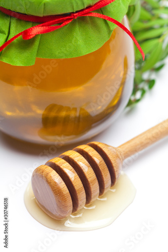 stick to hohey and jar of honey isolated on white
