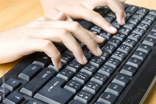 Hands typing  on a keyboard.