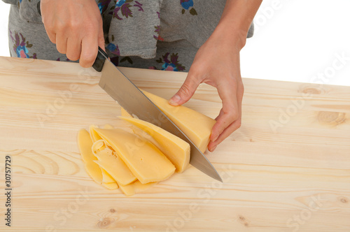 housewife cutting cheeseon a wooden board