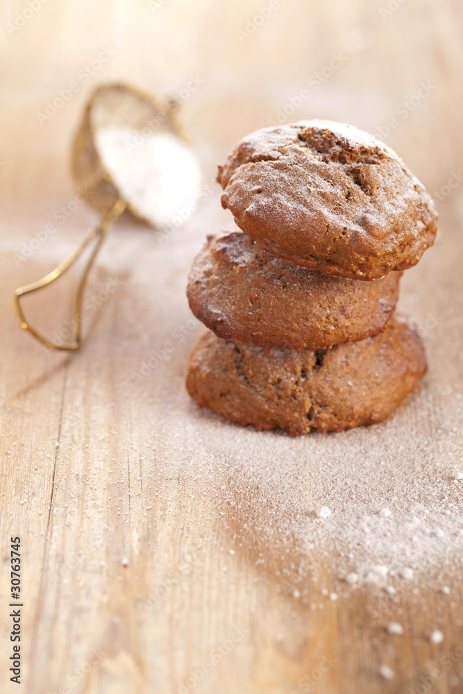 soft ginger cookies three stacked and dusted on wooden table