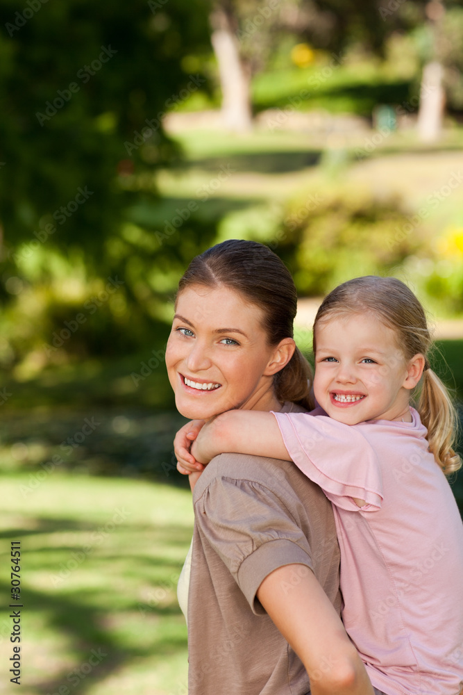 Beautiful mother giving daughter a piggyback Beautiful mother giving daughter a piggyback