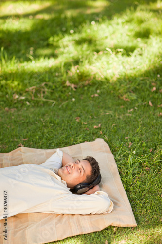 Young man listening to music in the park