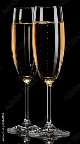 A glass of champagne, isolated on a black background.