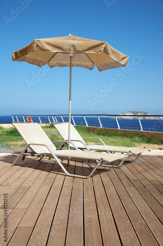 two deck-chairs with umbrella
