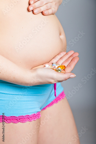 Pregnant woman holding pharmaceutical drugs