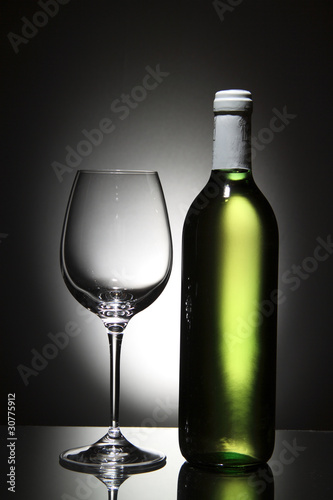 Bottle of white wine and empty wine glass