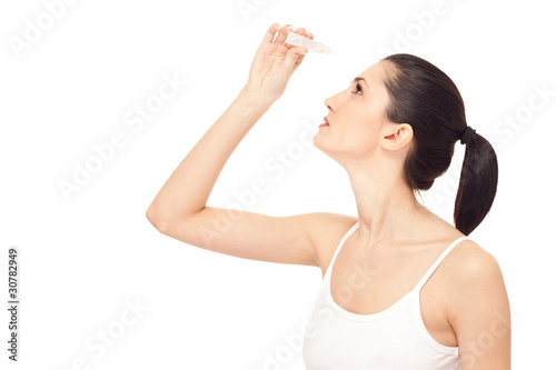 woman dripping eye with eyes drops photo
