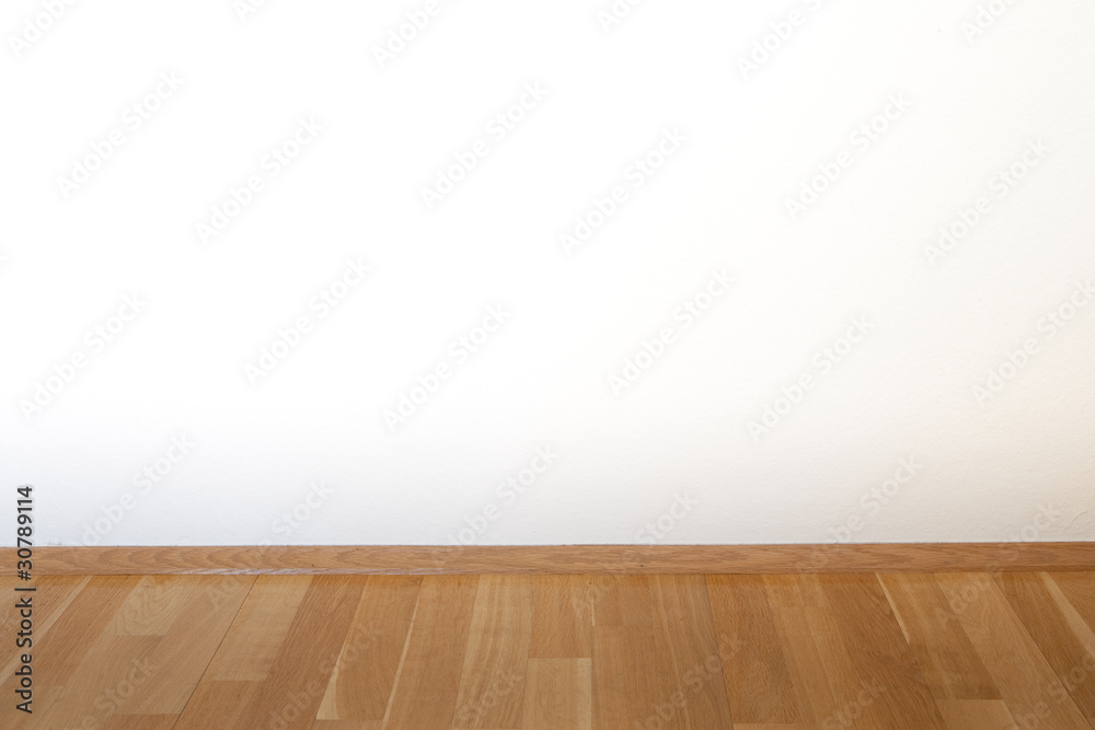 Naklejka premium Parket und weiße Wand in einem leeren Zimmer