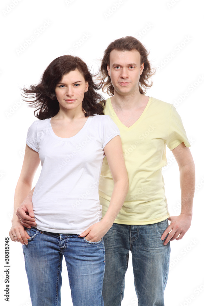 Portrait of young couple in jeans, serious boy embraces girl