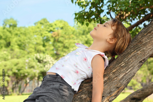 Little girl lies on caudex of tree photo