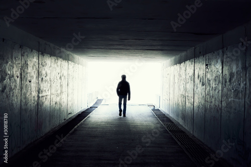 Fotografia Silhouette of Man Walking in Tunnel. Light at End of Tunnel