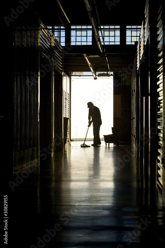Silhouette of man moping floor © gustavotoledo