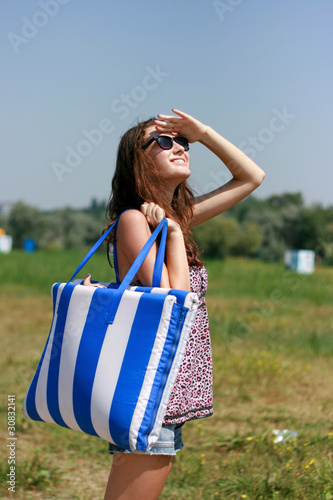 Happy young woman with beach bag