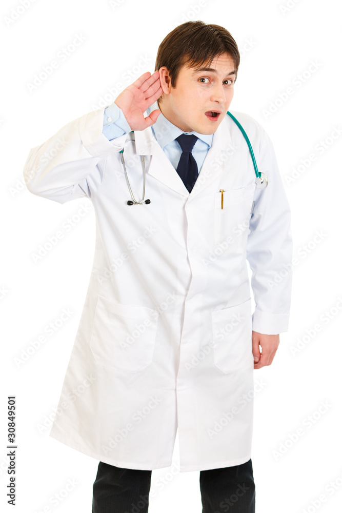 Concentrated medical doctor holding hand at ear and listening Concentrated medical doctor holding hand at ear and listening