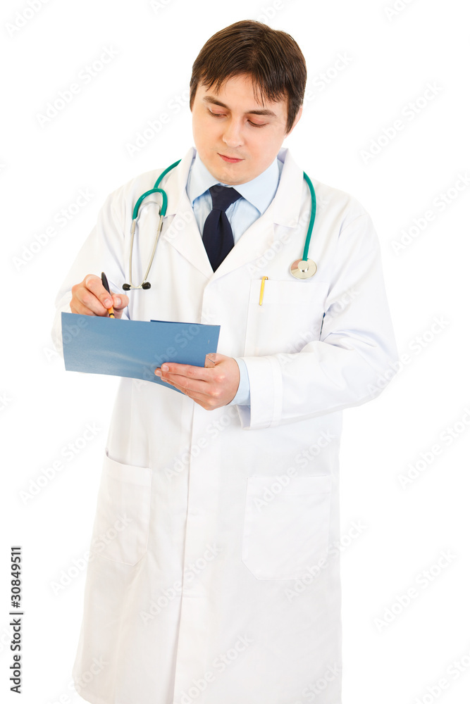 Serious doctor with stethoscope making notes in medical chart Serious doctor with stethoscope making notes in medical chart