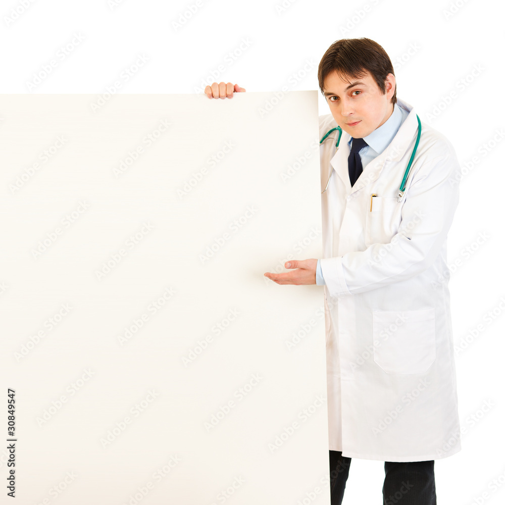 Authoritative medical doctor pointing on blank billboard Authoritative medical doctor pointing on blank billboard