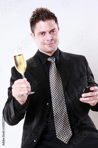 Businessman cheers with his cellphone in hand