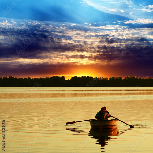 Couple in boat against a beautiful sunset © wajan