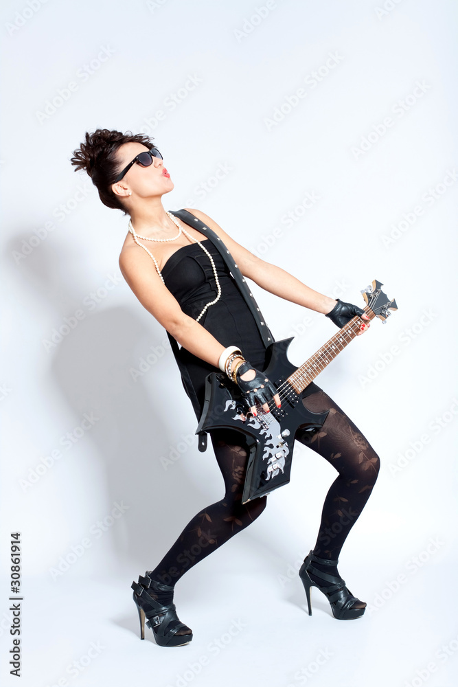 Woman in black dress playing the guitar