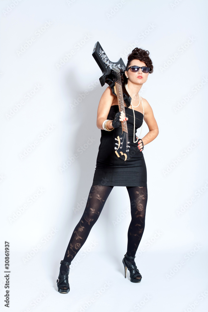 Fashion woman in black dress,holding a electric guitar Fashion woman in black dress,holding a electric guitar