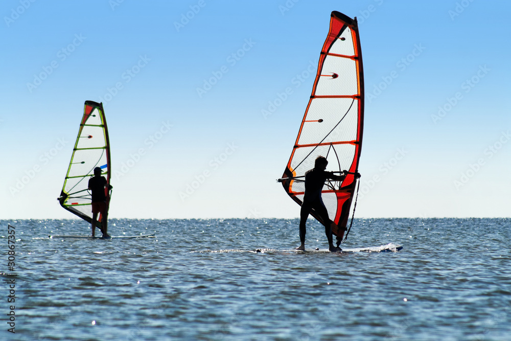 Naklejka premium Silhouette of a two windsurfers
