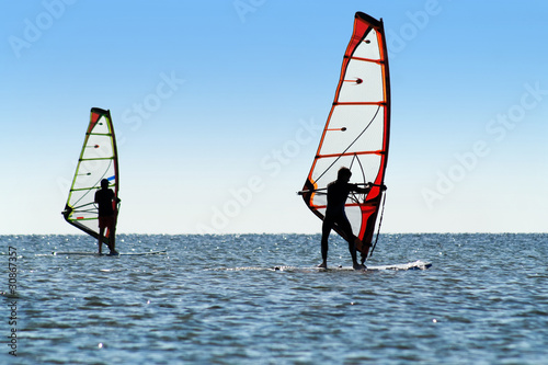 Silhouette of a two windsurfers