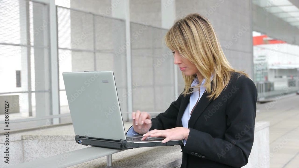 Businesswoman working on laptop computer outside Businesswoman working on laptop computer outside
