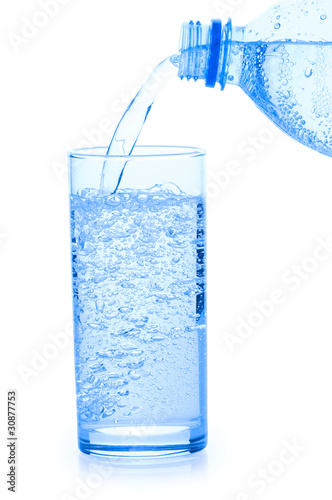 Stream ofwater fallind in glass from bottle