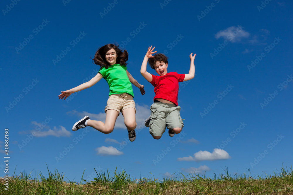 Girl and boy jumping, running against blue sky Girl and boy jumping, running against blue sky