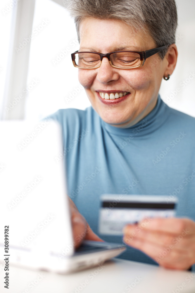 senior woman using credit card and laptop senior woman using credit card and laptop
