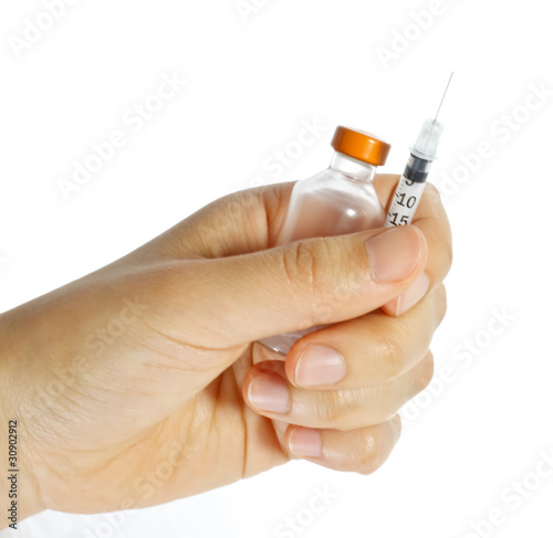 Hand holding a syringe and vial