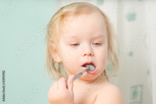 Adorable baby eat honey with small spoon. Spoon in mouth