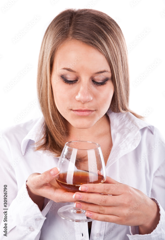 Young woman smelling cognac in a glass Young woman smelling cognac in a glass