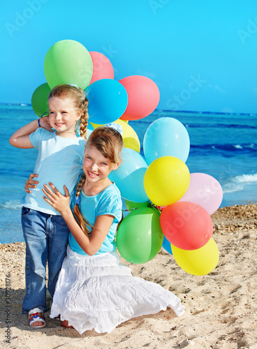 Children playing with balloons at the beach