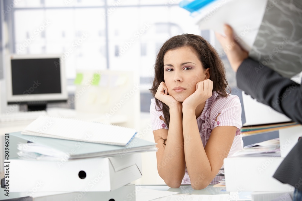 Attractive girl sitting among folders in office Attractive girl sitting among folders in office
