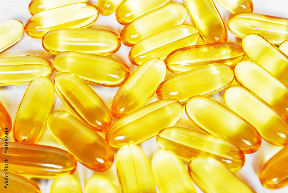 shiny yellow fish oil capsule pills closeup shiny yellow fish oil capsule pills closeup