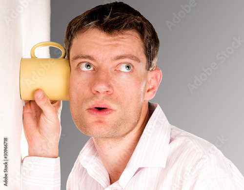 Man listening through the wall with the cup