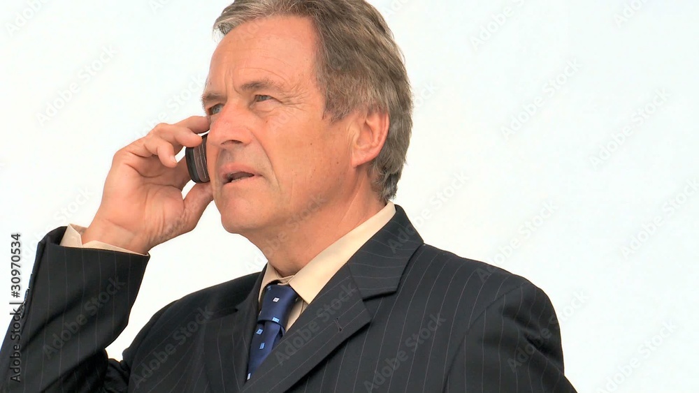 Aged businessman in suit taking a phone call Aged businessman in suit taking a phone call