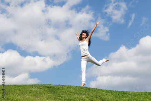 pretty young woman jumping on green grass © Dmytro Sunagatov