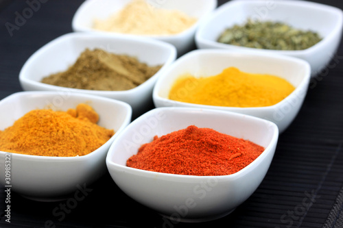 Different variety of spices  on black mat