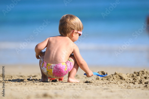 Niño jugando en la playa con la arena