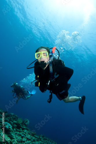 scuba divers exsplore coral reef in the red sea