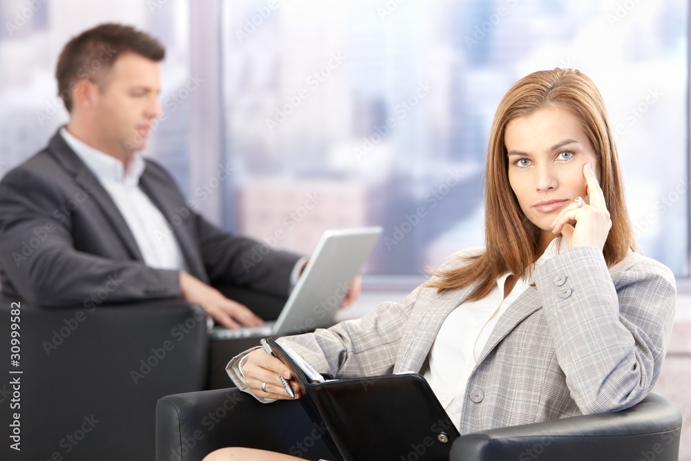 Attractive businesswoman sitting in office lobby Attractive businesswoman sitting in office lobby