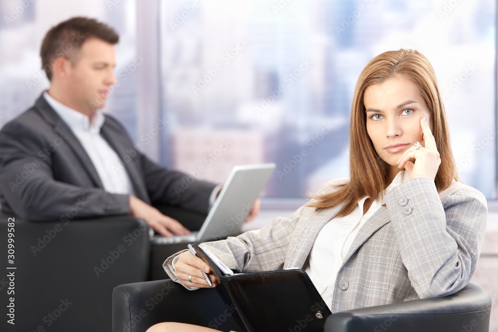 Attractive businesswoman sitting in office lobby