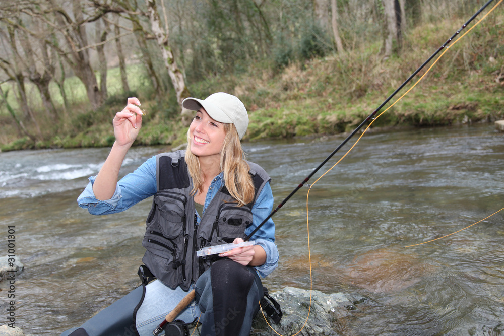 Woman fly-fishing in river Woman fly-fishing in river