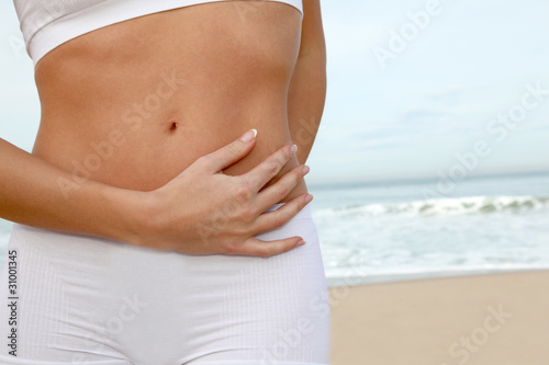 Fotografi Closeup of woman's body stretching on the beach