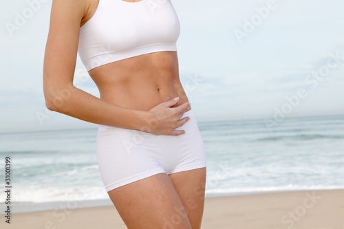 Closeup of woman's body stretching on the beach photo