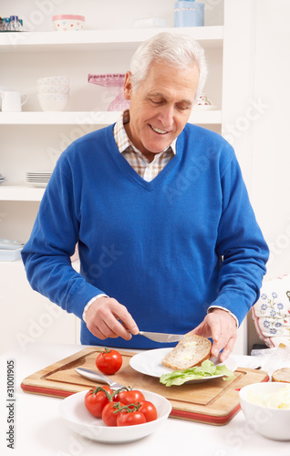 Senior Man Making Sandwich In Kitchen